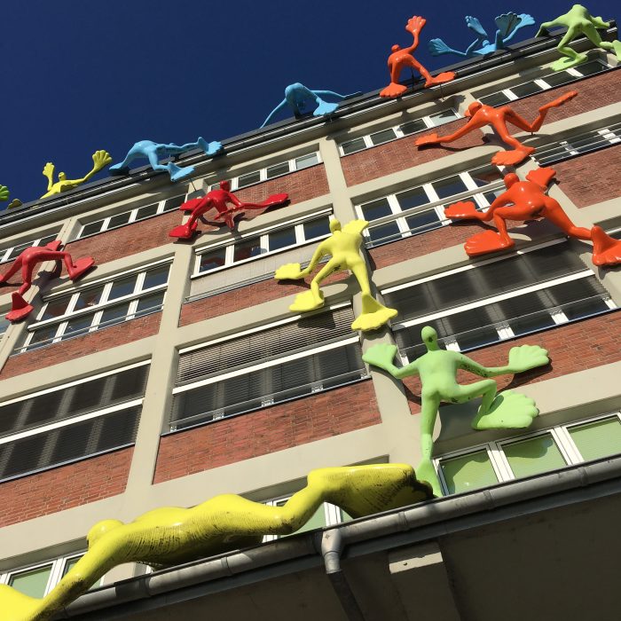 Rosalie's Flossis figures climbing a building in Düsseldorf Mediahafen